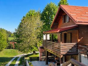 a log cabin with a balcony and a tree at Kuća za odmor Cozy Bear Cabin in Brestova Draga
