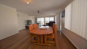a dining room with a wooden table and chairs at Pilot Unit 1 - Lifestyle Yamba in Yamba