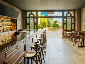 a bar with a row of stools in a restaurant at Fiesta Americana Aguascalientes in Aguascalientes