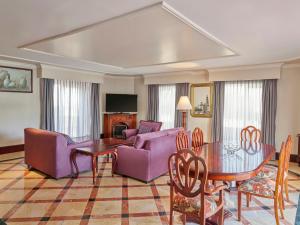 a living room with purple furniture and a table at Fiesta Americana Aguascalientes in Aguascalientes