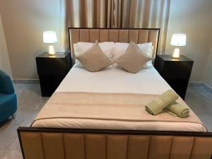a large bed with two night stands and two lamps at KJ Apartments in Lilongwe