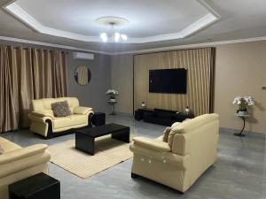 a living room with two couches and a flat screen tv at KJ Apartments in Lilongwe