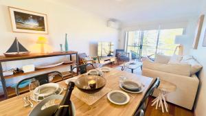 a living room with a table and a couch at Seaspray Views - Lifestyle Yamba in Yamba +13 photos
