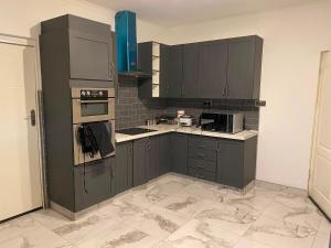 a kitchen with dark gray cabinets and appliances at KJ Apartments in Lilongwe