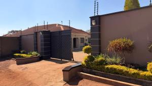 a house with a fence and a courtyard with plants at KJ Apartments in Lilongwe