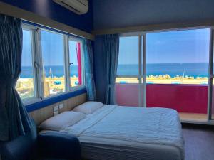 a bedroom with a bed with a view of the ocean at I WoW in Xiaoliuqiu