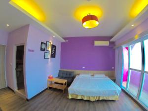 a bedroom with a bed and a purple wall at I WoW in Xiaoliuqiu