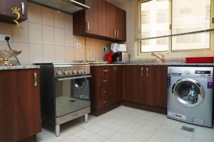 a kitchen with a washing machine and a washer at Serene 1BR Retreat in Baniyas in Abu Dhabi