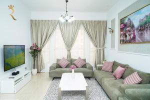 a living room with a couch and a tv at Serene 1BR Retreat in Baniyas in Abu Dhabi