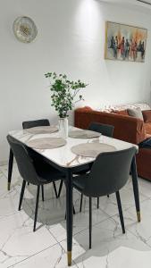 a table with chairs and a vase with a plant on it at Le Terracotta Panoramic View Bingerville in Bingerville