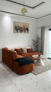 a living room with a brown couch and a table at Le Terracotta Panoramic View Bingerville in Bingerville