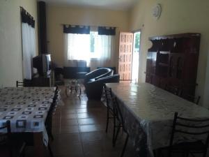 sala de estar con mesas y sillas y sala de estar. en Rocio de Luna en Mina Clavero