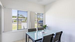 a dining room with a glass table and two chairs at Sunnyvale 2 - Lifestyle Yamba in Yamba