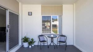 a porch with two chairs and a table and a window at Sunnyvale 2 - Lifestyle Yamba in Yamba