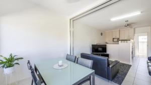 a living room with a dining table and a kitchen at Sunnyvale 2 - Lifestyle Yamba in Yamba