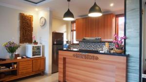 a kitchen with a counter with a refrigerator and a microwave at Lebak Nelayan in Canggu
