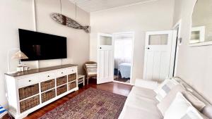 a living room with a flat screen tv on a wall at Surf Side - Lifestyle Yamba in Yamba