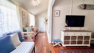 a living room with a couch and a flat screen tv at Surf Side - Lifestyle Yamba in Yamba