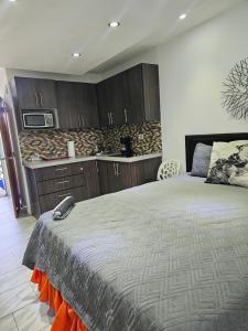 a bedroom with a bed and a kitchen with a microwave at Sea breeze vacation lll en Condominio Verde mar in San Juan