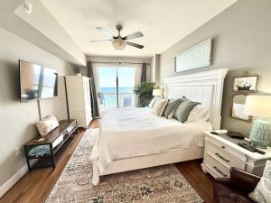 a bedroom with a bed and a window with the ocean at Blue Heron Beach Front in Panama City Beach