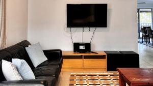 a living room with a couch and a flat screen tv at The Perch - Lifestyle Yamba in Yamba
