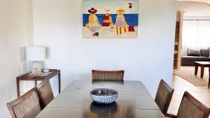 a dining room with a table with chairs and a painting at The Perch - Lifestyle Yamba in Yamba