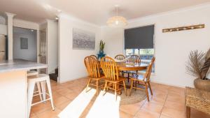 a kitchen and dining room with a table and chairs at Yamba Beach House - Lifestyle Yamba in Yamba