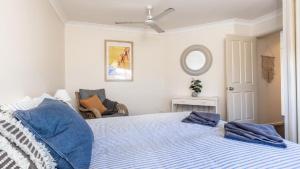 a bedroom with a bed with blue pillows on it at Yamba Beach House - Lifestyle Yamba in Yamba +10 photos