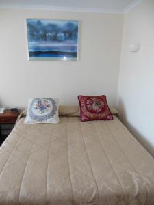 Ein Bett oder Betten in einem Zimmer der Unterkunft ASURE Camelot Arms Motor Lodge