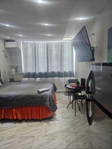 a bedroom with a bed and a table in it at Sea breeze vacation lll en Condominio Verde mar in San Juan +15 photos