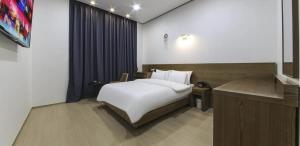 a bedroom with a bed and a desk in a room at 호텔 누리다 Hotel Nurida in Sayang-ni +5 photos