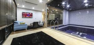 a bathroom with a tub in the middle of a room at 호텔 누리다 Hotel Nurida in Sayang-ni
