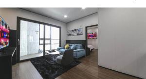 a living room with a blue couch and a tv at 호텔 누리다 Hotel Nurida in Sayang-ni