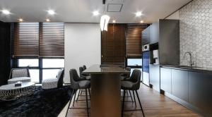 a kitchen with a table and some chairs and a counter at 호텔 누리다 Hotel Nurida in Sayang-ni