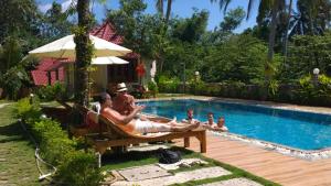 a group of people laying in chairs by a pool at Sun & Wind Paradise Bungalow in Phu Quoc