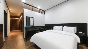 a bedroom with a white bed and a mirror at 호텔 누리다 Hotel Nurida in Sayang-ni
