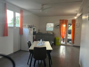 a kitchen with a table and chairs in a kitchen at Villa SCAYOU in Pointe-Noire