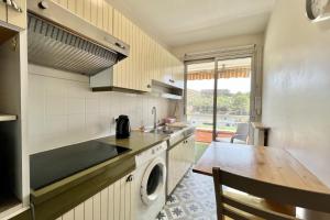 a kitchen with a washing machine and a table at Bright studio just outside Cannes in Le Cannet
