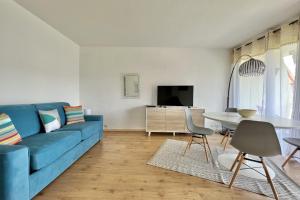 a living room with a blue couch and a table at Bright studio just outside Cannes in Le Cannet