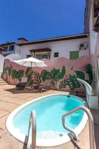 a swimming pool in front of a building with a mural at D'Ajuda Inn in Arraial d'Ajuda +32 photos