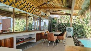 a dining room with a table and chairs and a swimming pool at Dayunan in Bacolod +12 photos