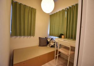 a bedroom with green curtains and a bed with a desk at WAMARE Shibamata, Entire private two-story house, Traditional Tokyo Stay with Easy Access to Haneda & Narita Airports, up to 4pax in Tokyo