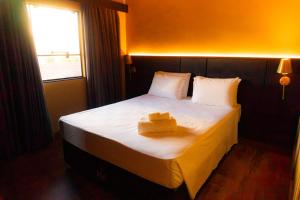 a bedroom with a bed with two boxes on it at Zagat Classic Hotel in Foz do Iguaçu