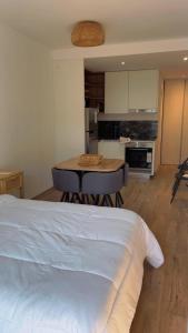 a bedroom with a bed and a table and a kitchen at Hermoso departamento Saavedra 4741 in Buenos Aires