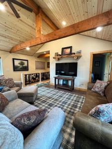 a living room with couches and a flat screen tv at Rustic Bay View Cabins- Lodge in Homer
