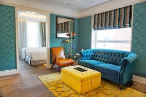 uma sala de estar com um sofá azul e uma cama em Hotel Madera Hollywood em Hong Kong