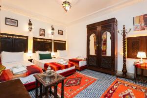 a living room with two beds and a table at Dar Houda in Fez