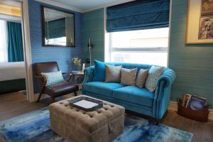 a living room with a blue couch and a chair at Hotel Madera Hollywood in Hong Kong