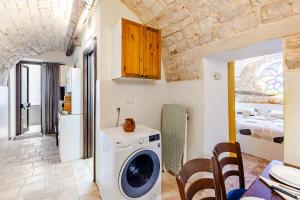 a kitchen with a washing machine in a room at Vitti Stone House - Centro Storico Castellana in Castellana Grotte