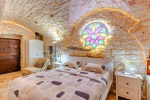 a bedroom with a large bed in a stone wall at Vitti Stone House - Centro Storico Castellana in Castellana Grotte